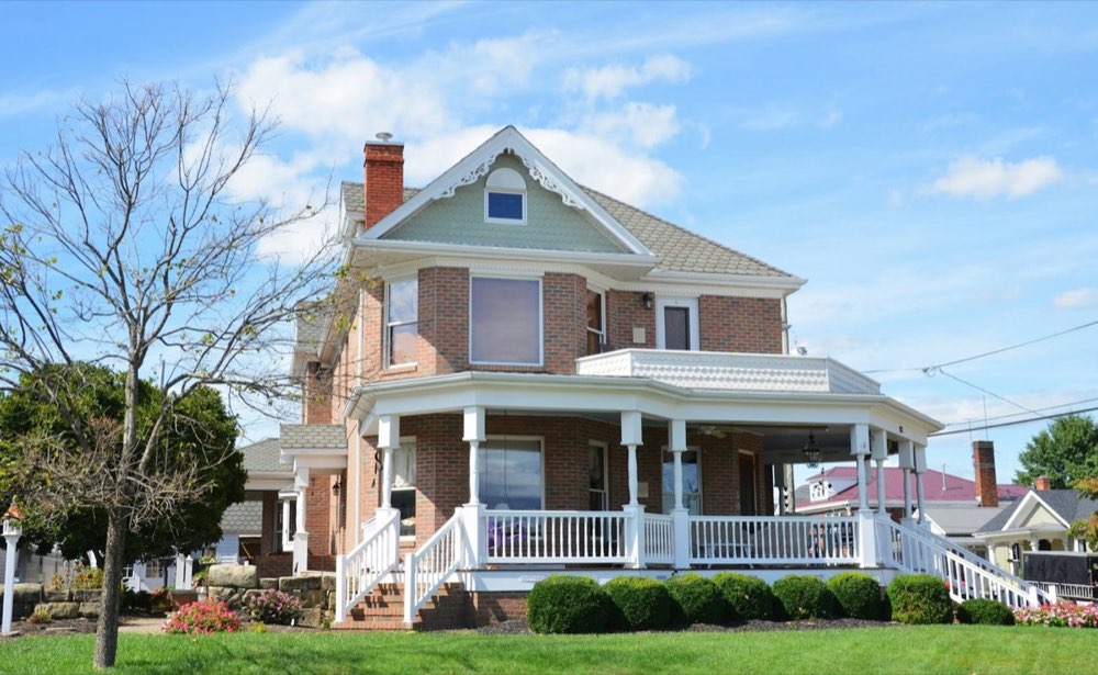 Two-story brick home with a wraparound porch ready to list for sale