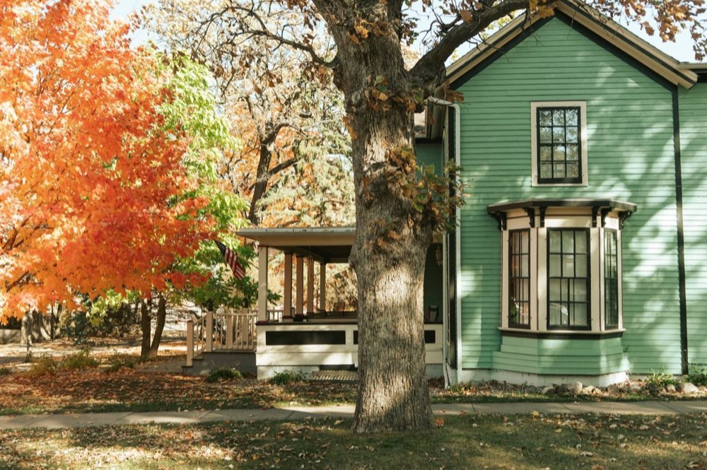 Older Victorian-style home with bay windows in the fall